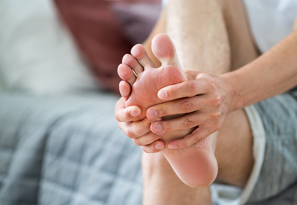 Man holding foot in pain from peripheral neuropathy